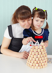 Image showing Mother and daughter play sitting at table