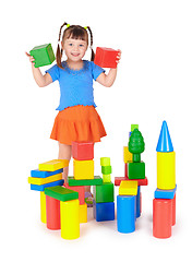 Image showing Little girl is playing with colored blocks