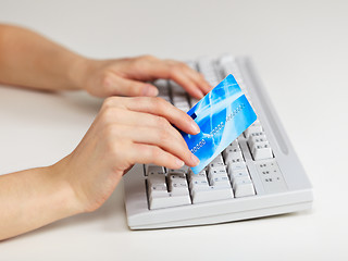 Image showing Hands with plastic credit card on computer keyboard