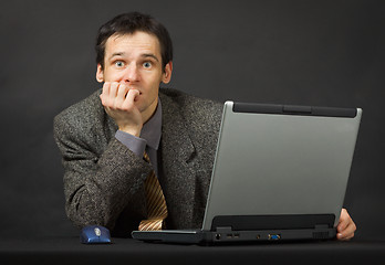 Image showing Surprised person with computer. Sits and thinks.