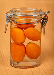 Image showing Kumquat in small tin can on wooden background