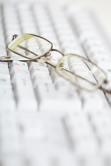 Image showing Spectacles on computer keyboard - poor eyesight