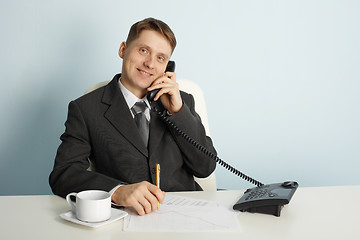 Image showing Smiling businessman in talks on phone