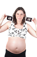Image showing Young woman holding a sonogram of her child