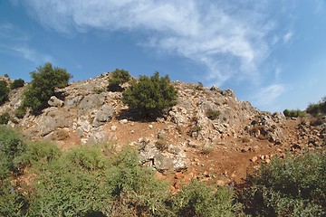 Image showing Round rocky hill with green bushes