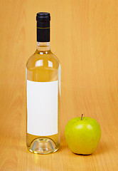 Image showing Bottle of cider and apple on table