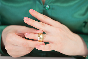 Image showing Woman tries on large gold ring