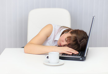 Image showing Woman tired and fell asleep at table with a laptop