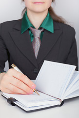 Image showing Businesswoman writes down plans in notebook