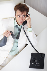 Image showing Young businessman talking on phone very excited