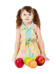 Image showing Little girl with apples sits isolated on white background