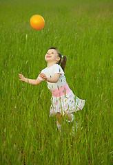 Image showing Child cheerfully plays with ball