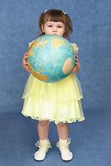 Image showing Little girl holding a large globe