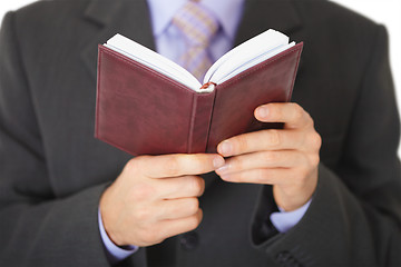 Image showing Man reads entries in notebook - close-up