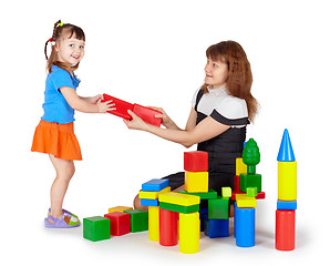 Image showing Little girl with mother playing with colored blocks