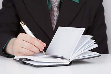 Image showing Woman does records in a diary close up