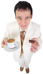 Image showing Funny young man drinking coffee with sweets