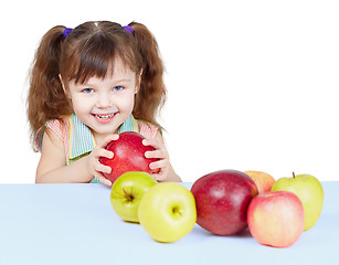 Image showing Little girl playing with fruits sitting at table