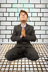 Image showing Comic businessman on knees praying