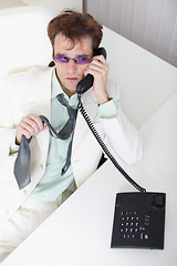 Image showing Uneasy young businessman speaks on phone