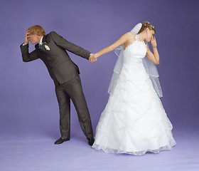 Image showing Comical emotional groom and bride holding hands