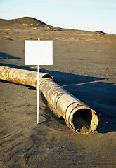 Image showing Sign near old rotting pipe - ecological disaster