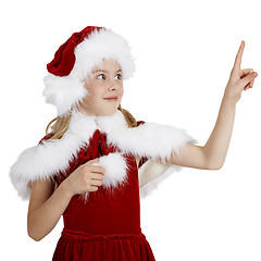 Image showing Surprised smiling girl in Christmas clothes points a finger