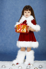 Image showing Little girl in fur New Year's clothes with gift