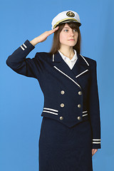 Image showing Girl in a sea uniform salutes on blue