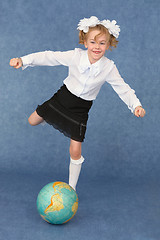 Image showing Schoolgirl kicks globe as footballer