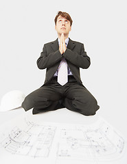 Image showing Builder prays to god sitting near drawing