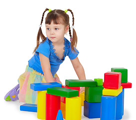 Image showing Little girl is playing with color bricks