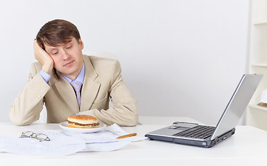 Image showing Businessman, dreamily looking at sandwich