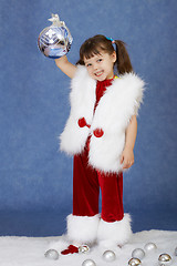 Image showing Little girl in New Year costume holding glass ball