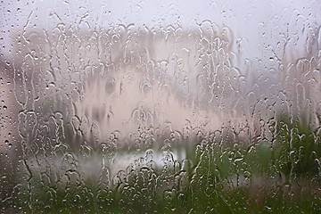 Image showing View through window with streams and drops of rain water