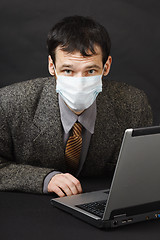 Image showing Man in medical mask works in Internet