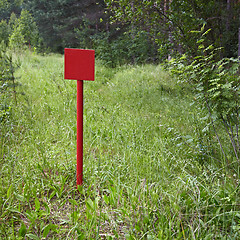 Image showing Red metal plate near forest