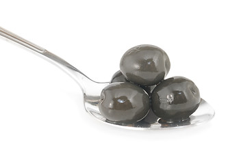 Image showing Whole black olives marinated in stainless spoon isolated on white