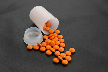 Image showing orange pill  black background