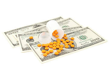 Image showing orange pill at the money , isolated on white background