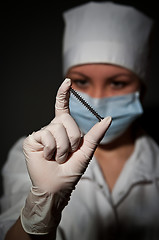 Image showing young pretty surgeon holding nail for osteosynthesis