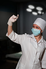 Image showing young pretty surgeon holding nail for osteosynthesis