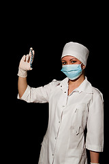 Image showing young pretty surgeon holding plate for osteosynthesis