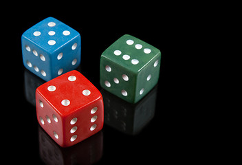 Image showing Red, green and blue dices on black background