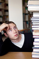 Image showing Stressed Student Looks At Book Pile