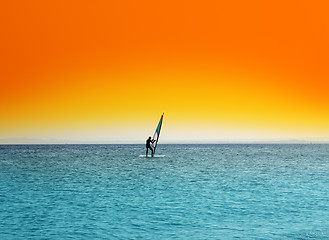 Image showing surfer on blue sea under orange sky