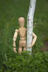 Image showing Wooden toy man hugging tree