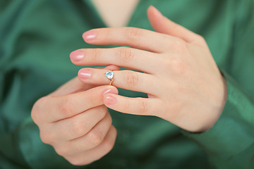 Image showing Gold ring with blue brilliant on female hand