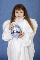 Image showing Child dressed as an angel with wings holding glass ball