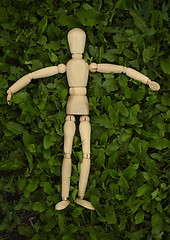 Image showing Toy wooden man on grass